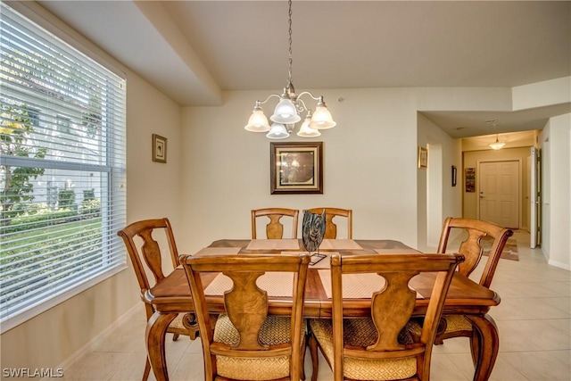 tiled dining area featuring an inviting chandelier