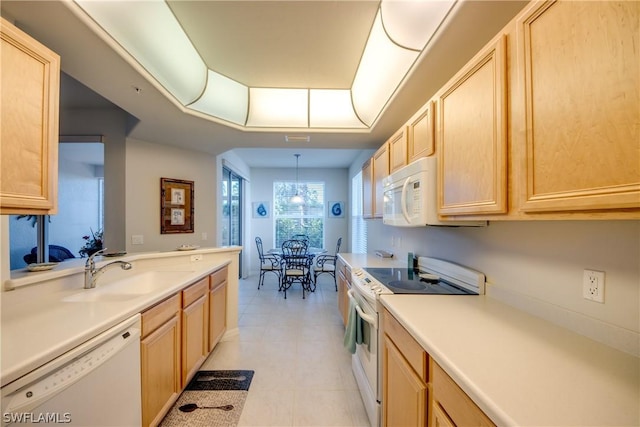 kitchen with sink, light brown cabinetry, and white appliances