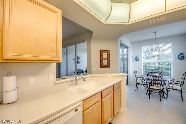 kitchen featuring decorative light fixtures, light brown cabinetry, sink, and dishwasher