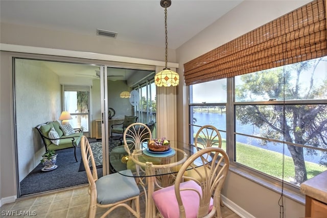 dining room featuring a water view and light tile patterned floors