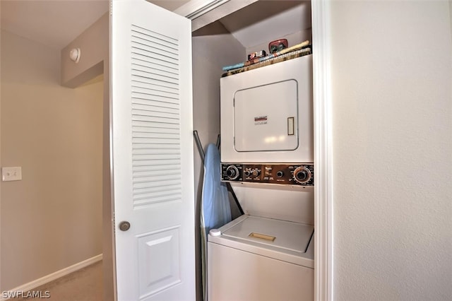 laundry room with stacked washer and dryer and carpet