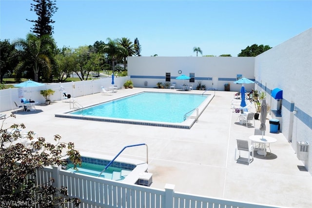 view of swimming pool featuring a patio and a community hot tub