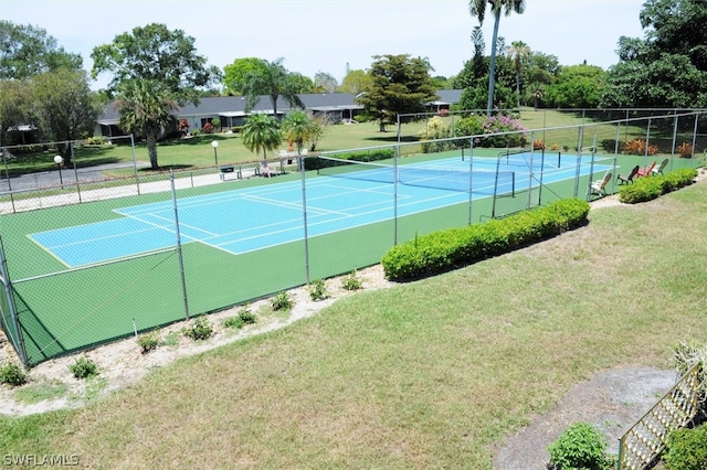 view of tennis court featuring a yard