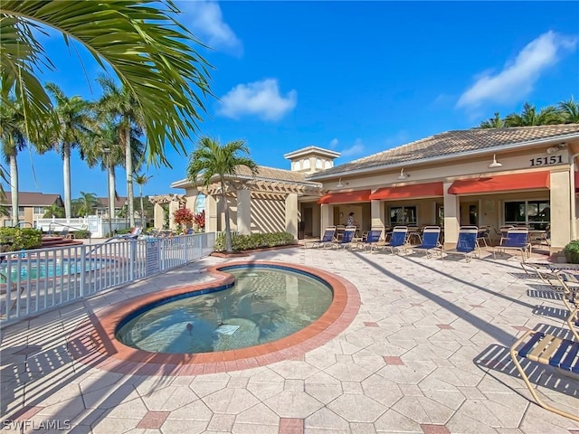 view of swimming pool with a community hot tub and a patio area