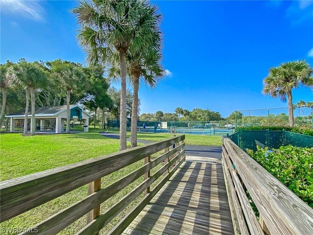 surrounding community featuring a yard and tennis court