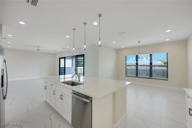 kitchen featuring light stone countertops, white cabinetry, sink, an island with sink, and stainless steel appliances