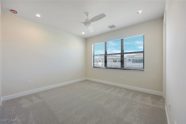 empty room featuring ceiling fan and light carpet