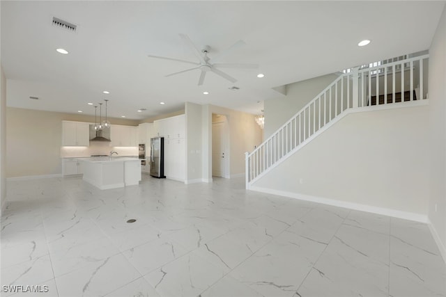 unfurnished living room with sink and ceiling fan