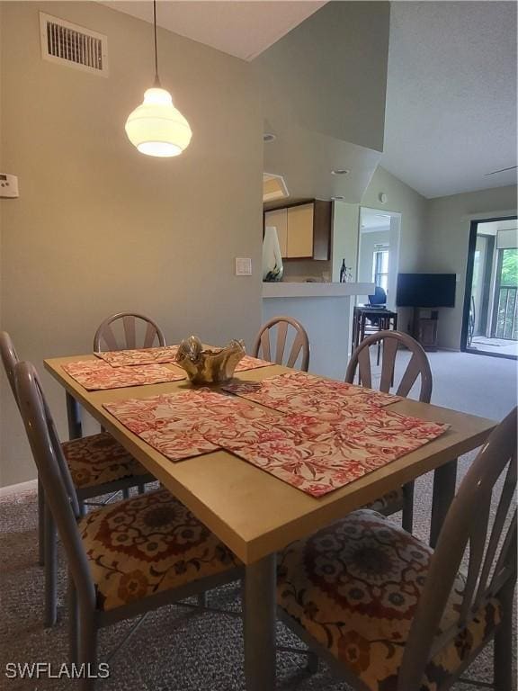 dining room featuring vaulted ceiling and carpet flooring