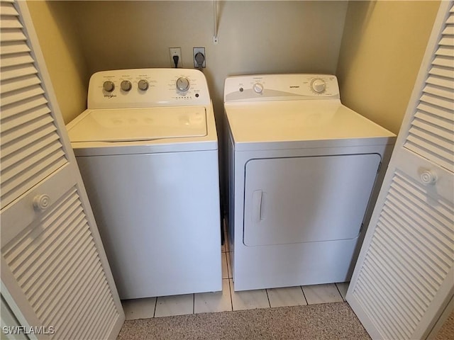 laundry room with light carpet, laundry area, light tile patterned floors, and washing machine and dryer