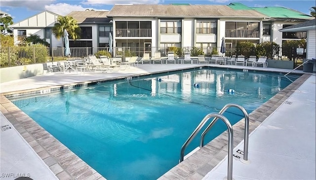 pool with a residential view, fence, and a patio