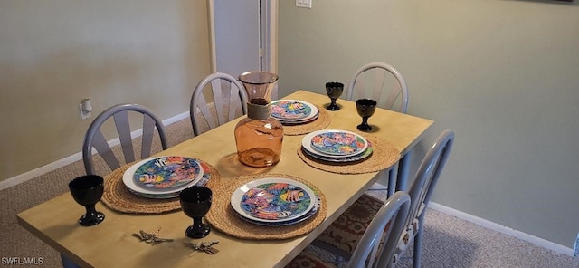 dining room featuring carpet flooring and baseboards