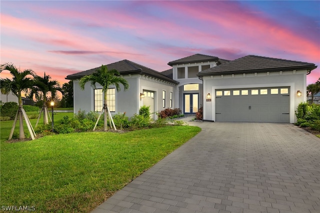 view of front of home featuring a garage and a yard