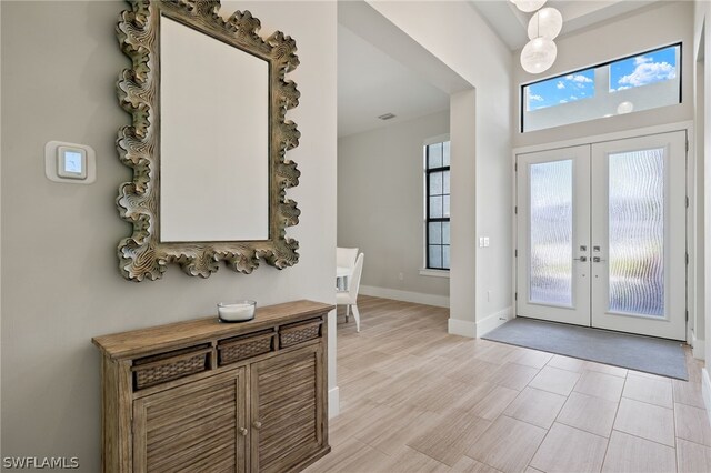 entrance foyer with french doors and light hardwood / wood-style flooring