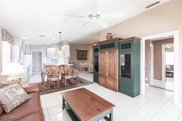 living room with ceiling fan, light tile patterned floors, beverage cooler, and lofted ceiling