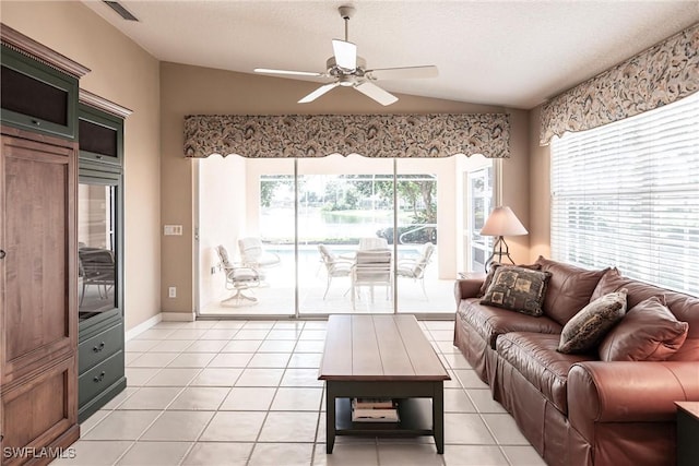 living room featuring ceiling fan, light tile patterned floors, and lofted ceiling