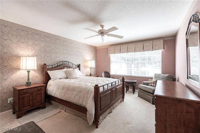 bedroom featuring light carpet, a textured ceiling, and ceiling fan