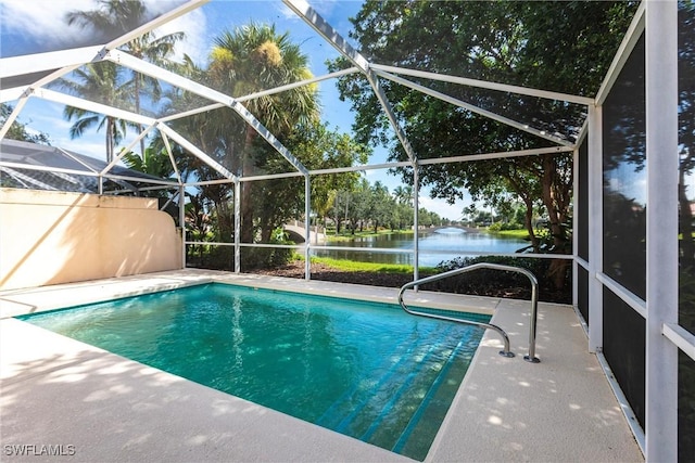 view of swimming pool featuring glass enclosure, a water view, and a patio