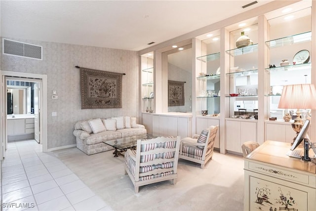 living area featuring built in shelves and light tile patterned floors