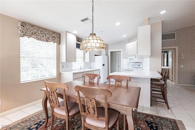 dining space featuring light tile patterned floors and a textured ceiling