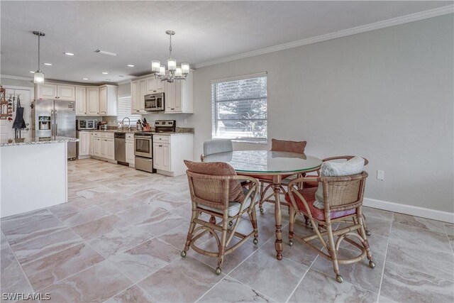 dining space with crown molding, a chandelier, and sink