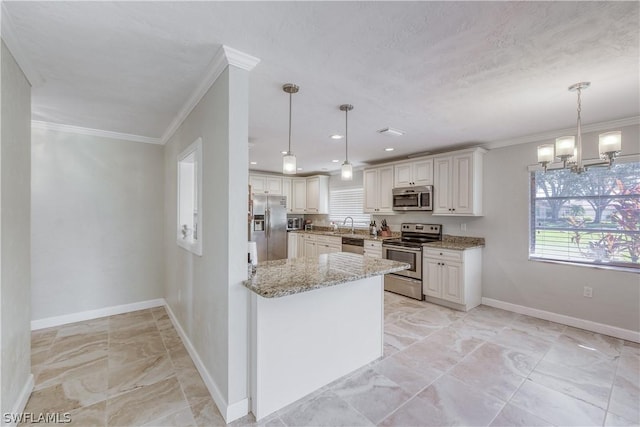 kitchen with appliances with stainless steel finishes, white cabinetry, light stone counters, ornamental molding, and decorative light fixtures