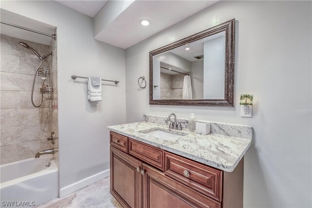 bathroom featuring vanity and tiled shower / bath