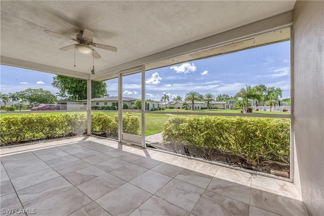 unfurnished sunroom with ceiling fan