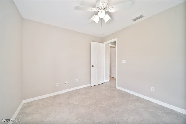 tiled spare room with ceiling fan