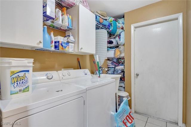 washroom featuring light tile patterned flooring, separate washer and dryer, and cabinets