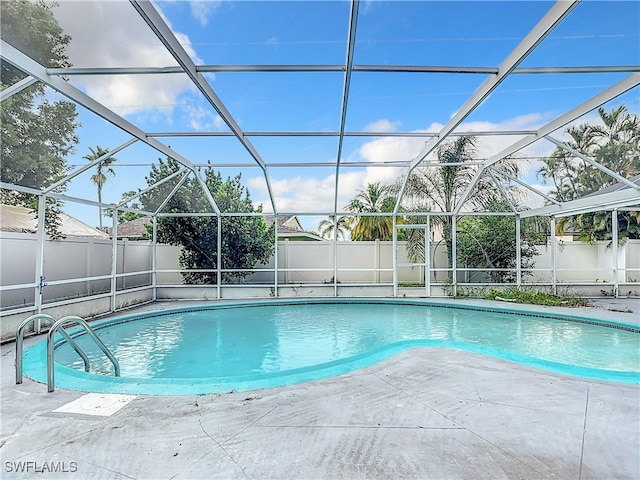 view of pool featuring glass enclosure and a patio area