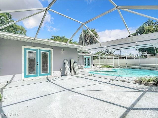 view of swimming pool featuring a patio, glass enclosure, and french doors