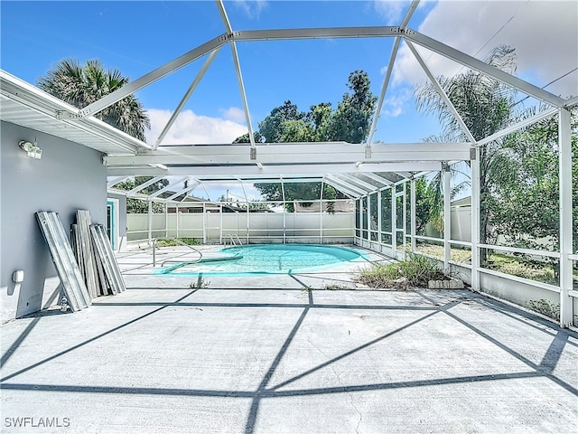 view of swimming pool with a patio and glass enclosure