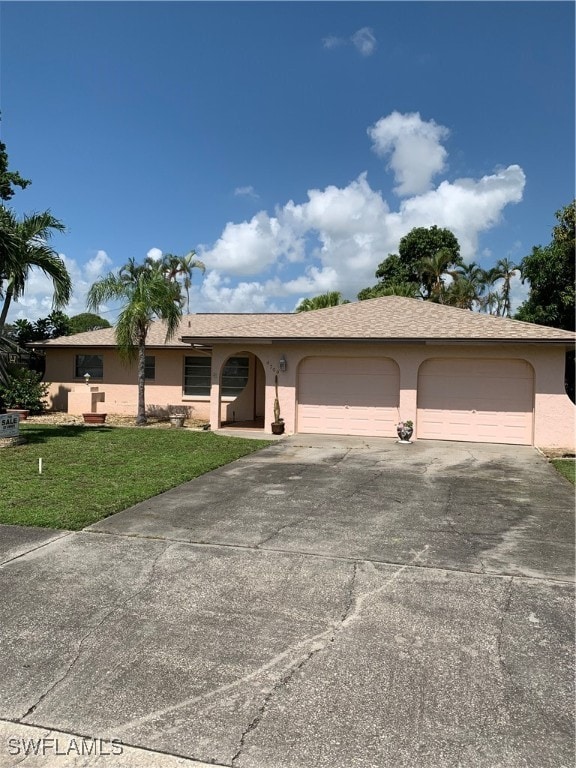 single story home with a garage and a front lawn