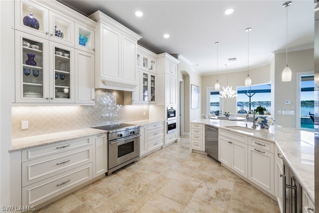 kitchen featuring appliances with stainless steel finishes, crown molding, sink, pendant lighting, and white cabinetry