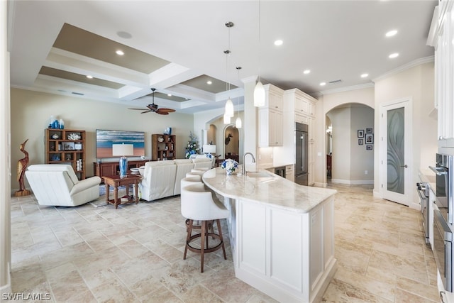 kitchen featuring beam ceiling, sink, coffered ceiling, stainless steel built in refrigerator, and decorative light fixtures