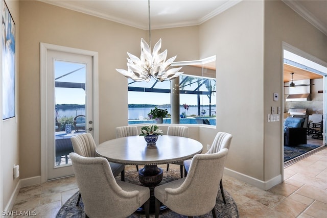 dining room with a notable chandelier, a water view, and ornamental molding