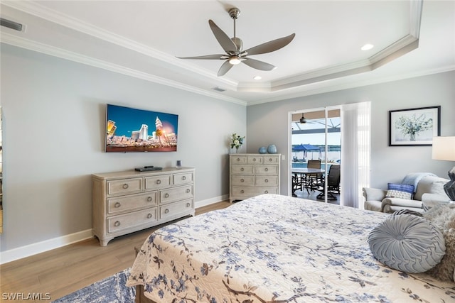 bedroom featuring access to exterior, ceiling fan, a raised ceiling, ornamental molding, and light wood-type flooring