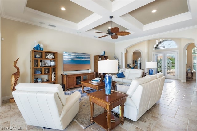 living room featuring coffered ceiling, french doors, ceiling fan with notable chandelier, crown molding, and beam ceiling