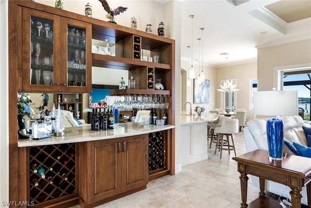 bar with light stone countertops, ornamental molding, and hanging light fixtures