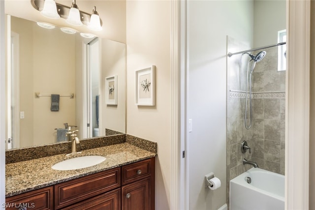 bathroom featuring vanity and tiled shower / bath