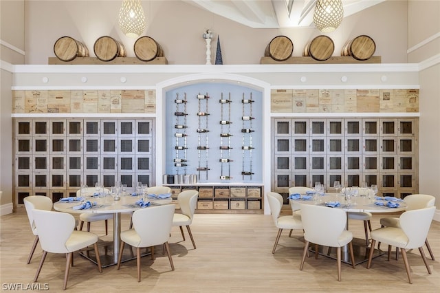 dining area featuring built in shelves, wood-type flooring, and a towering ceiling