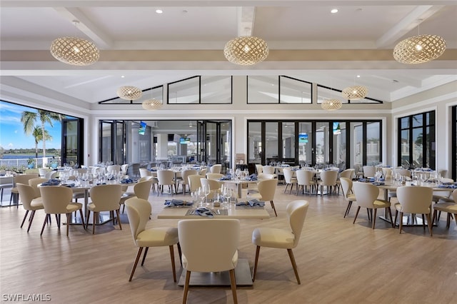 dining space featuring an inviting chandelier, lofted ceiling, and light hardwood / wood-style flooring