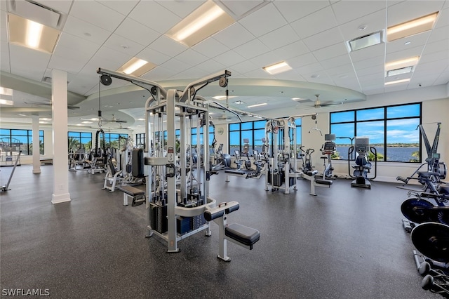 exercise room with a paneled ceiling and ceiling fan