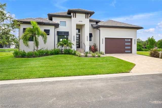 prairie-style home featuring a front lawn and a garage