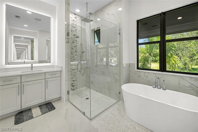 bathroom featuring vanity, shower with separate bathtub, and tile walls