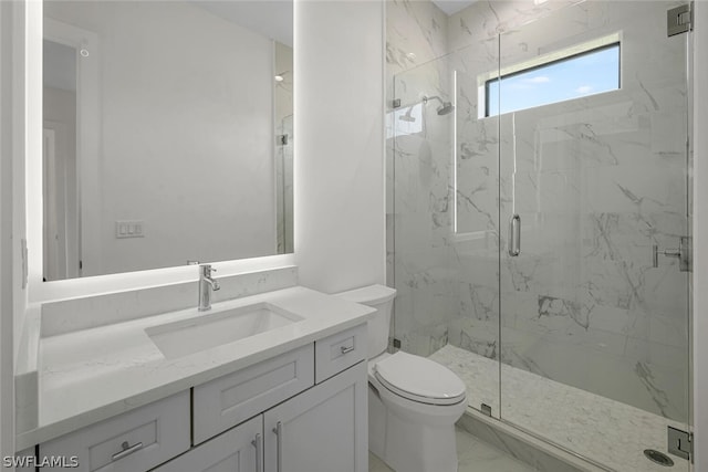 bathroom featuring vanity, a shower with shower door, and toilet