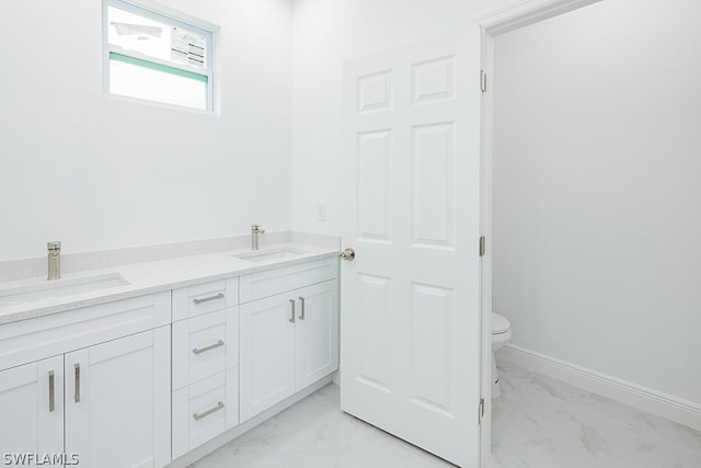 bathroom with dual vanity, toilet, and tile patterned floors