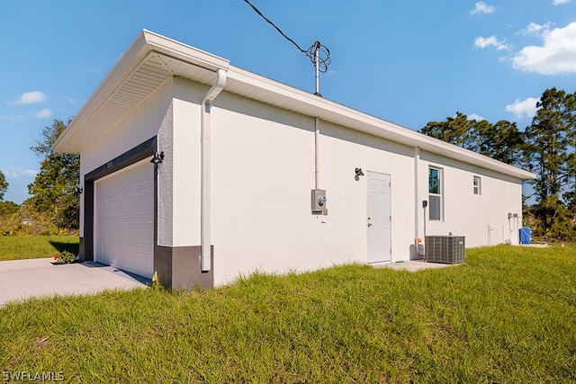 view of home's exterior with central air condition unit, a garage, and a yard