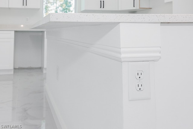 room details with white cabinetry and light tile patterned flooring